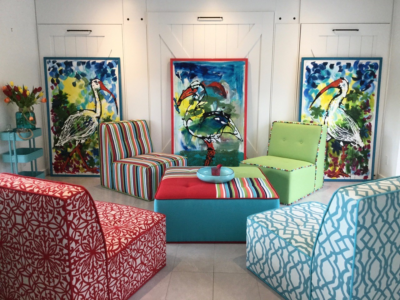 Bird paintings on wall with colourful couches